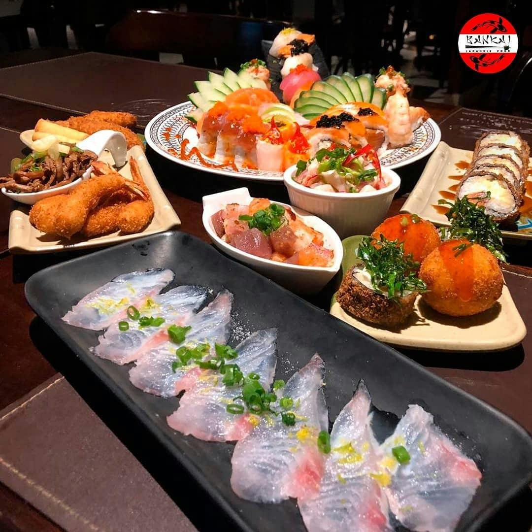 Culinária japonesa com variedade de sushis e sashimis, temakis e pratos quentes, em ambiente simples.
