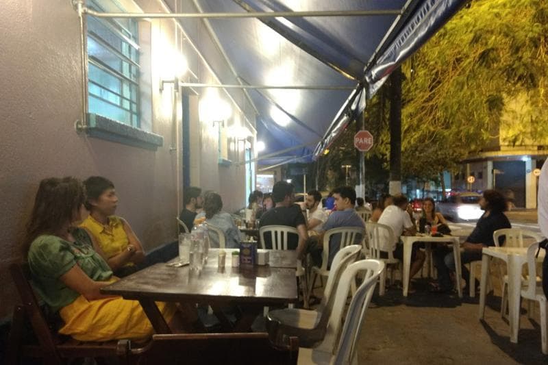 Peixes fritos e espetinhos, além de bolinhos de bacalhau com chope, em espaço informal com mesas na calçada.