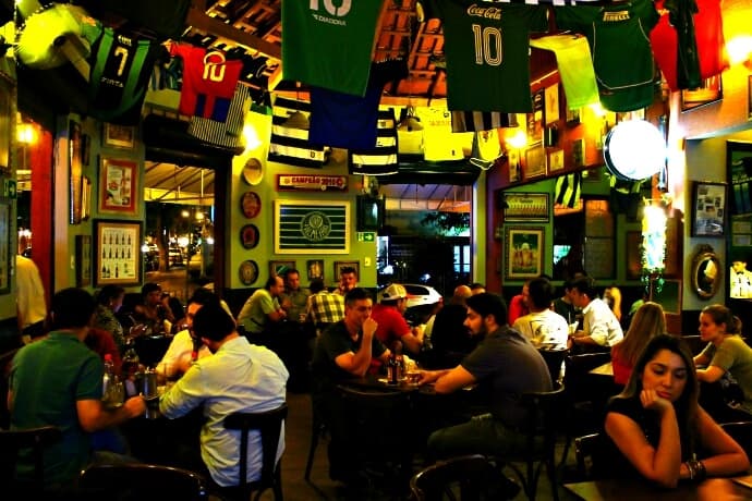 Cervejas, bolinhos, caldos e camisas de futebol no teto, em boteco aconchegante com clima dos anos 30 e 40.