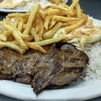 A culinária brasileira do filé com fritas, e menu de opções variadas, servidas em restaurante do dia a dia.