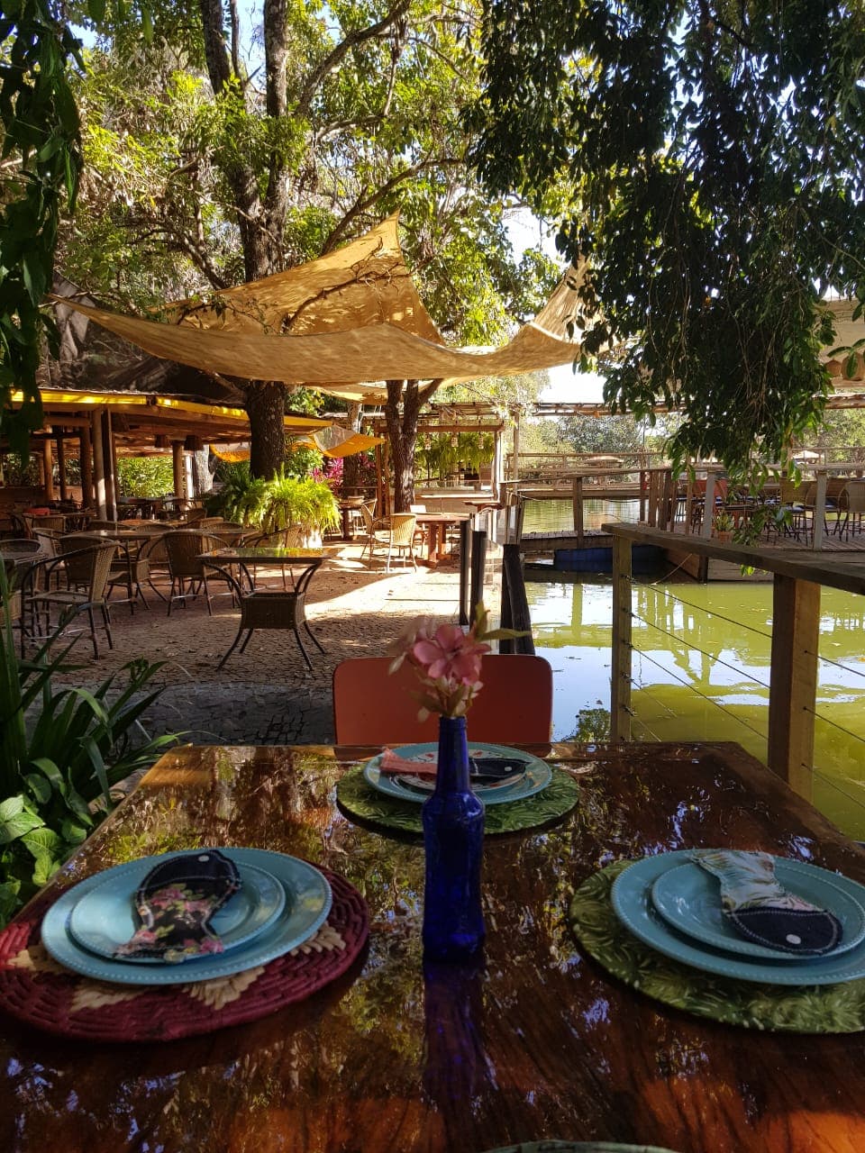 Restaurante e bar fino em antiga tulha de café serve menu de carnes e frutos do mar, com mesas na beira do lago